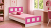 Cordoba kids single bed with paneled headboard and footboard in Barbie Pink, styled in a kids' room.